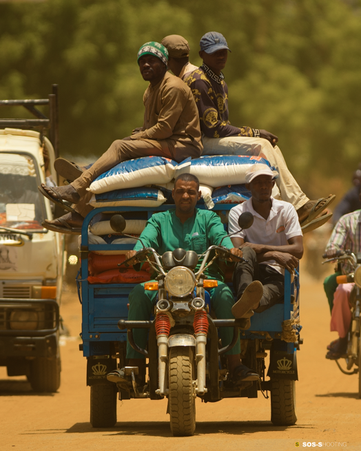 Hassane Chaibou Nari — Niamey, Niger. On a dusty road, men and goods move forward together towards their destination on a cargo tricycle.