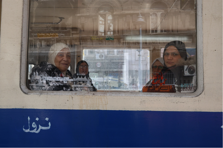 Amira Adel — Alexandria, Egypt. Inside Alexandria’s tram, reflections of streets and buildings merge with passengers’ faces in the window.