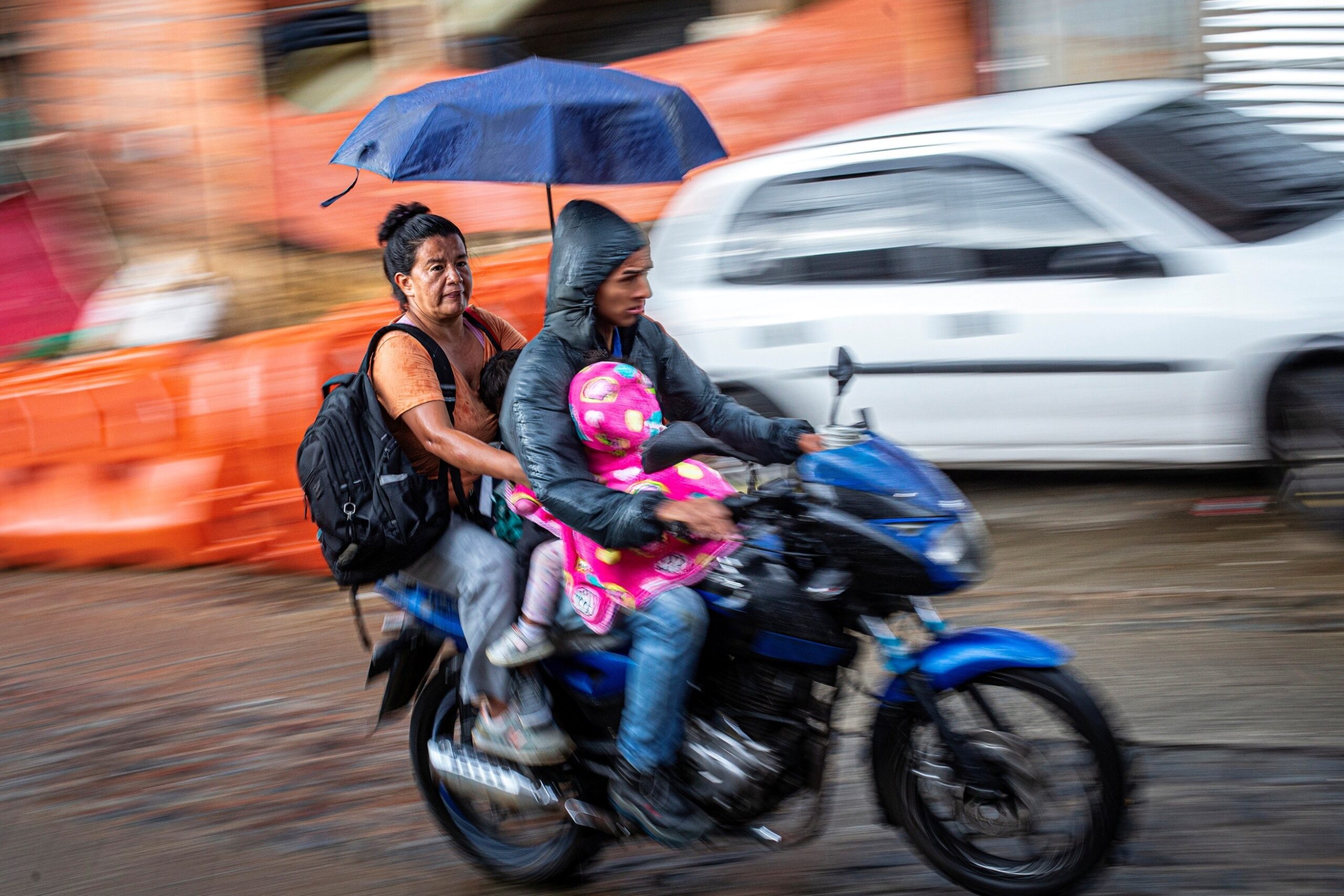 Pedro Londoño — Medellín, Colombia. Four people — two children and two adults — travel at full speed on a single motorcycle.